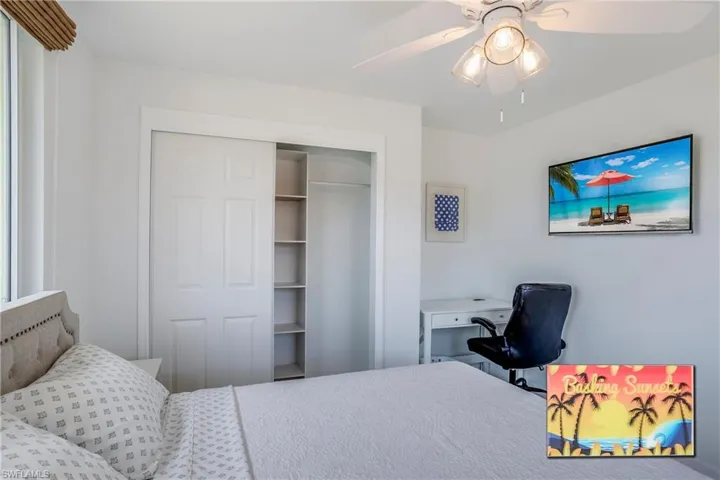 Bedroom with a closet, a desk, and ceiling fan