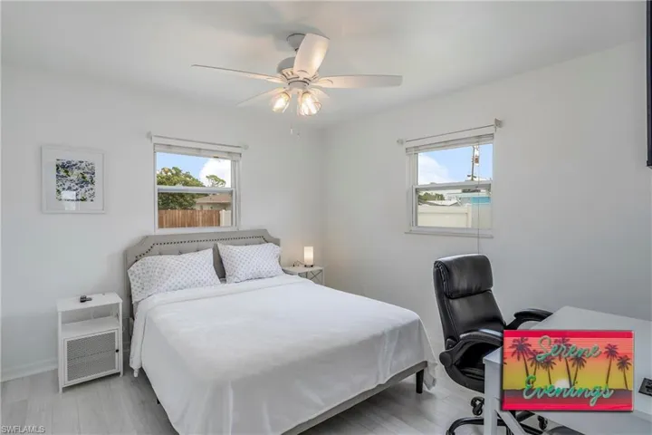 Bedroom featuring light wood-style flooring, ceiling fan, and a desk