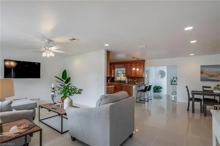 Living room featuring light tile patterned flooring, recessed lighting, and ceiling fan