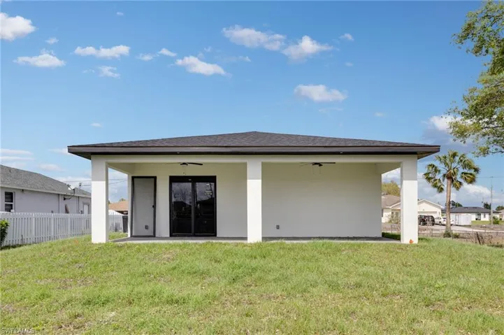 Rear view of house featuring a ceiling fan, stucco siding, and a patio