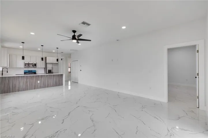 Unfurnished living room with recessed lighting, ceiling fan, and light marble finish floors