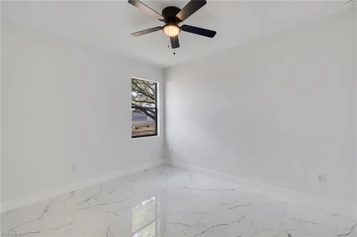 Spare room featuring ceiling fan and light marble finish floors