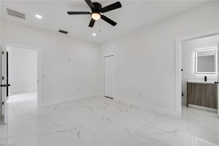 Unfurnished bedroom with recessed lighting, light marble finish flooring, ceiling fan, and a closet