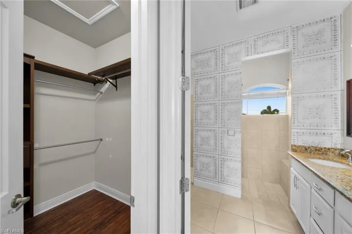 Bathroom with a spacious closet, vanity, and tile patterned flooring