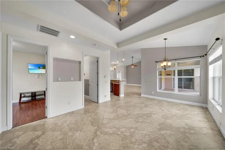 Empty room with a chandelier, baseboards, and ceiling fan