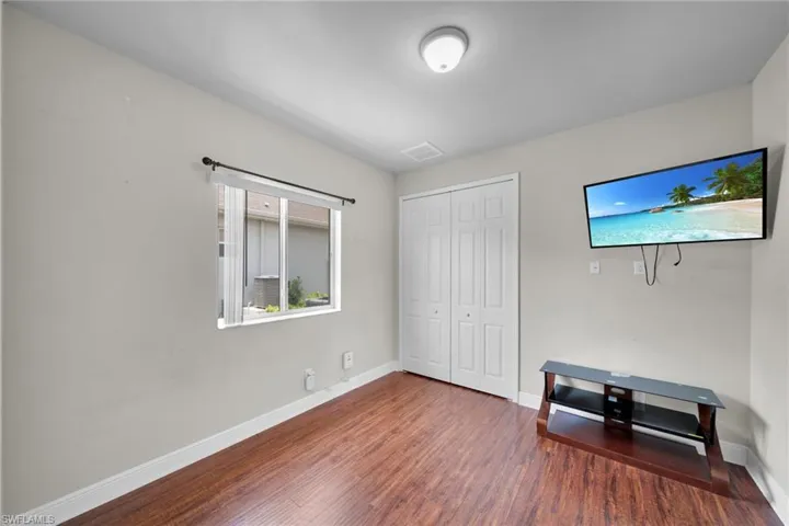 Unfurnished bedroom with wood finished floors, baseboards, and a closet