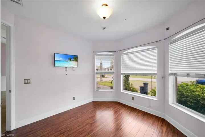 Unfurnished room featuring dark wood-style flooring and baseboards