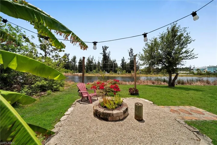 View of grassy yard with a water view and a patio