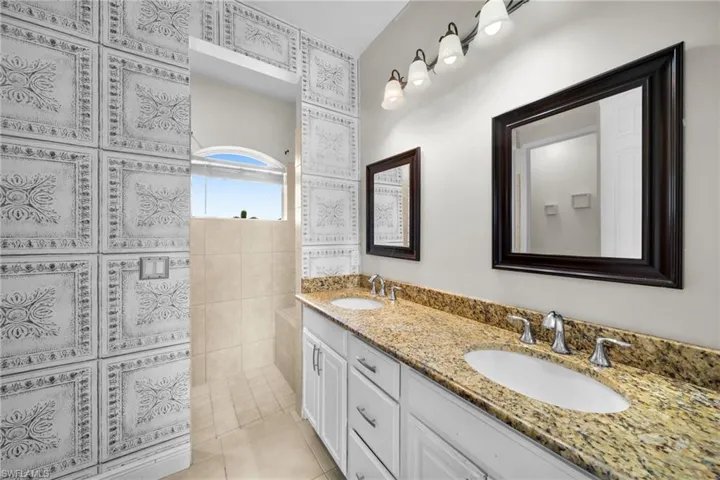 Full bathroom with a walk in shower, double vanity, and tile patterned flooring