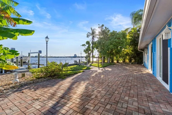 The patio is paved and extends to a grassy area by trees
