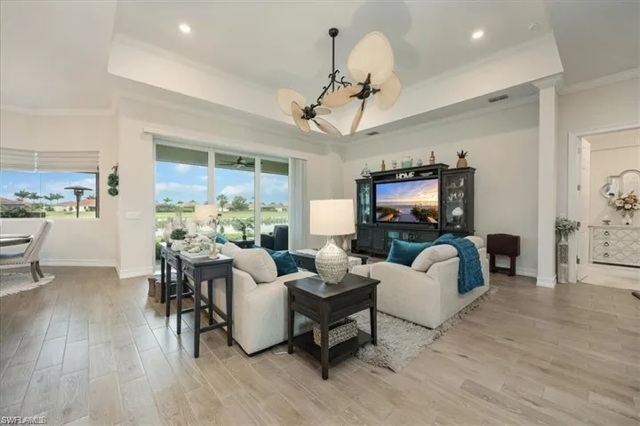 Wood-finish flooring throughout, tray ceiling with recessed lighting, and a ceiling fan