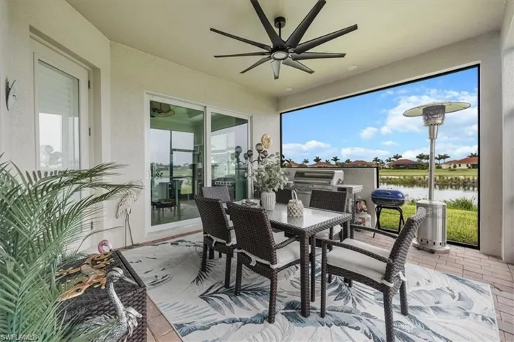 Covered outdoor patio with a ceiling fan, sliding glass doors, and a built-in outdoor kitchen