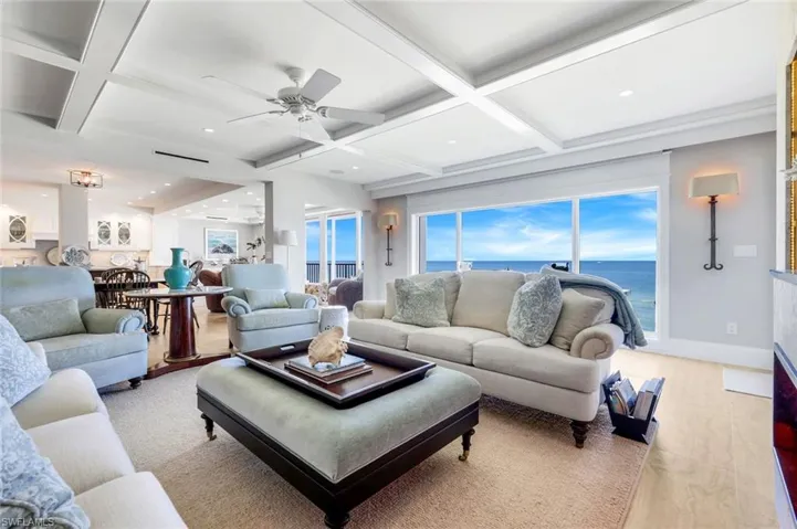Living area featuring coffered ceiling, beamed ceiling, a water view, recessed lighting, and a ceiling fan