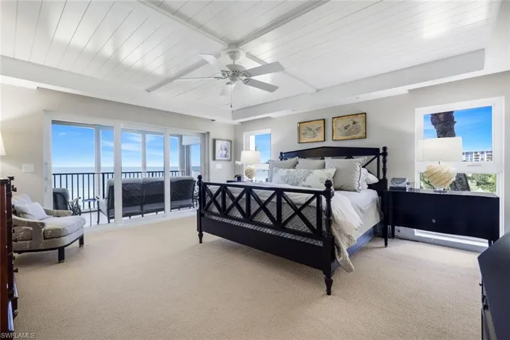 Bedroom with light colored carpet, a wood ceiling with exposed beams, access to exterior, and a ceiling fan