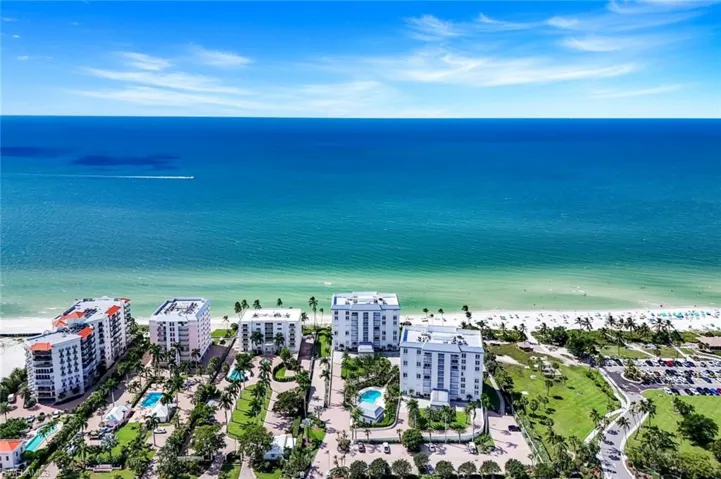 Drone / aerial view of waterfront with a beach and a pool