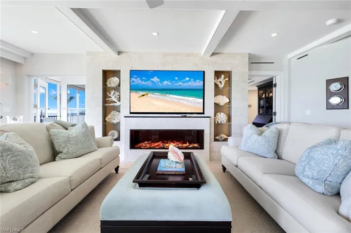 Living room featuring beam ceiling, a fireplace, recessed lighting, built in shelves, and carpet