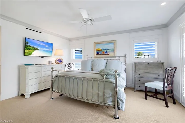 Bedroom with light carpet and a ceiling fan