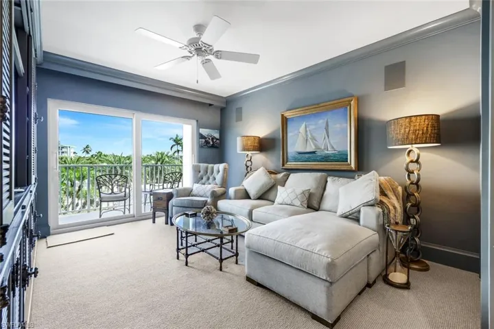 Living area featuring crown molding, carpet, and ceiling fan
