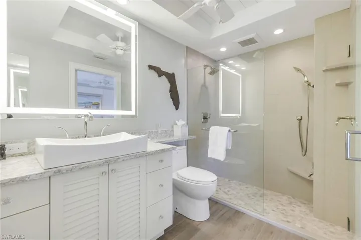 Full bathroom with ceiling fan, vanity, a stall shower, and recessed lighting