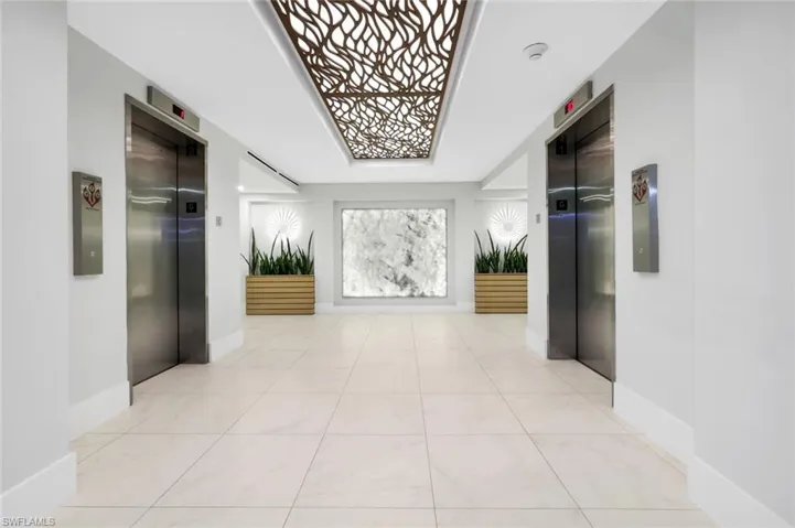 Corridor featuring light tile patterned floors and elevator