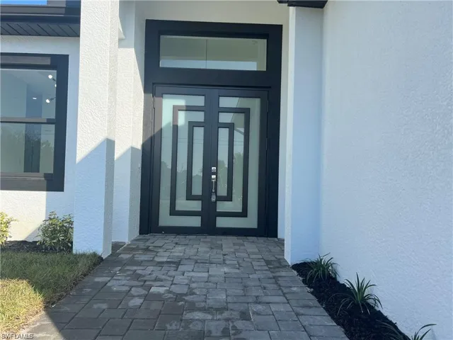 Property entrance with stucco siding and french doors