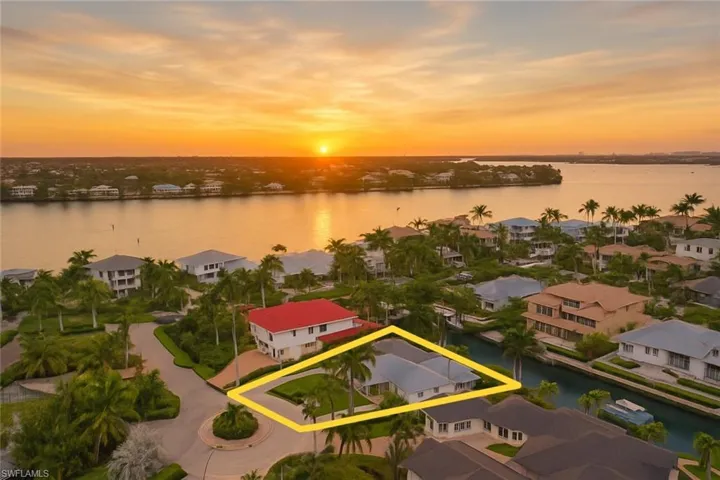 Aerial perspective of suburban area with a large body of water and property parcel outlined