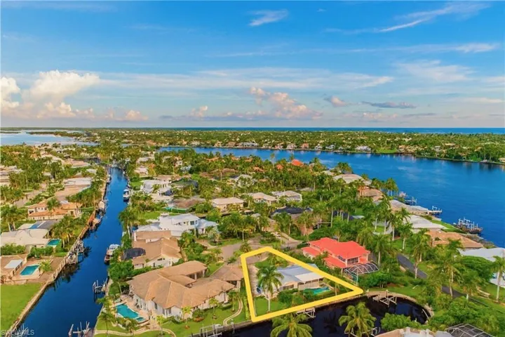 Aerial perspective of suburban area with property boundaries highlighted and a nearby body of water