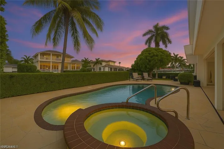 View of pool with a patio and a pool with connected hot tub