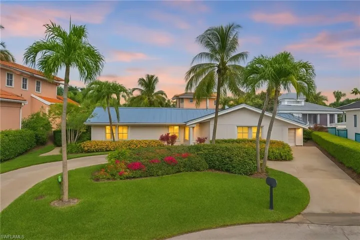 View of front of property featuring concrete driveway, a front yard, a metal roof, and stucco siding