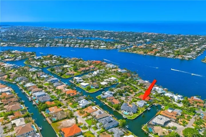 Aerial view of property's location featuring a nearby body of water and nearby suburban area