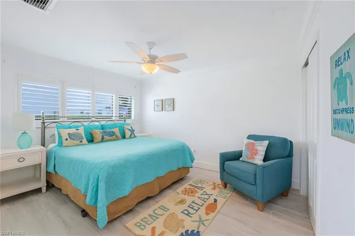 Bedroom featuring crown molding, a ceiling fan, light wood-style floors, and a closet