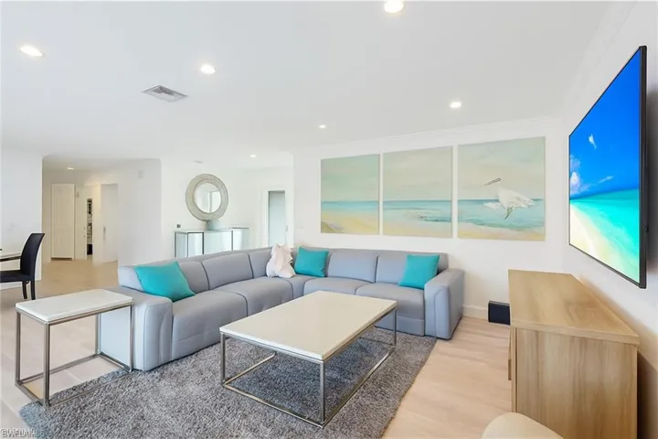 Living room featuring recessed lighting, light wood-style floors, and crown molding