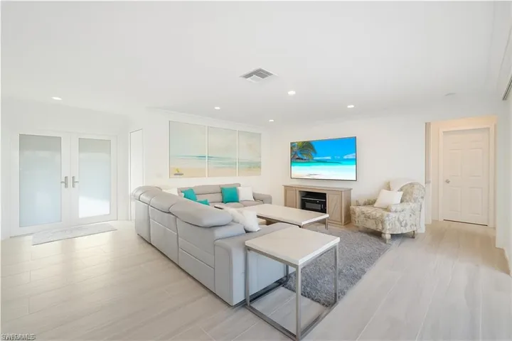 Living area featuring light wood-style floors, french doors, and recessed lighting