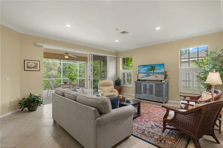Tiled living room featuring ornamental molding and new recessed lighting