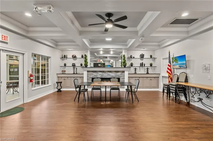 Clubhouse with wood-style floors, stone fireplace, and coffered ceiling