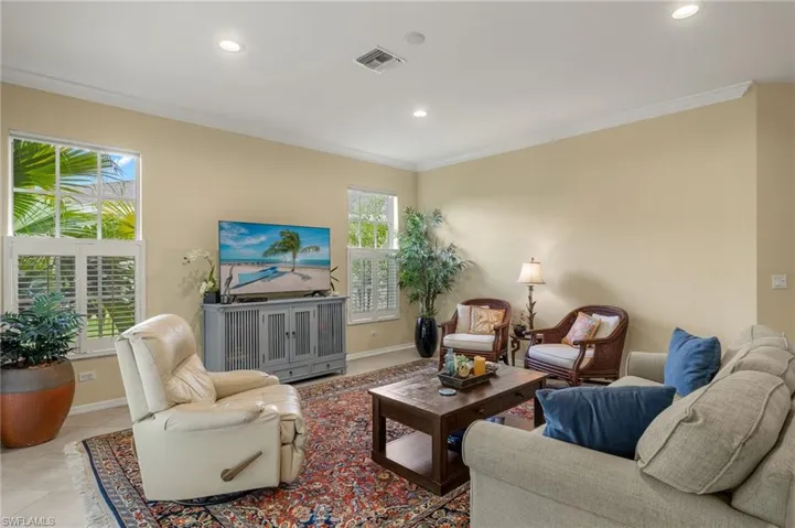 Living room featuring crown molding and plantation shutters