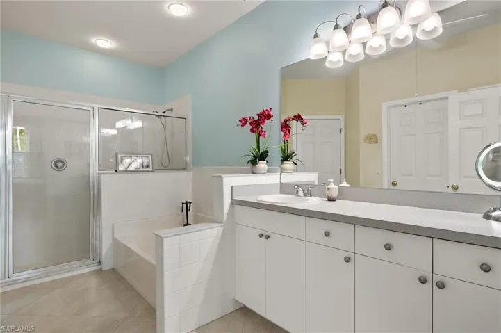 Bathroom featuring vanity, soaking tub and separate shower