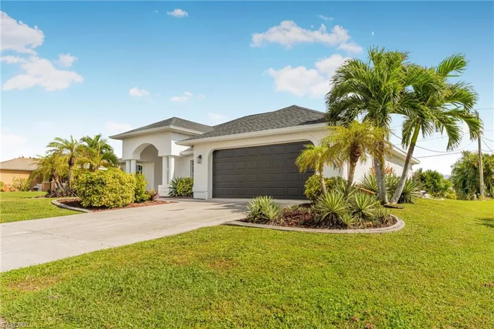 Mediterranean / spanish house featuring a garage and a front lawn