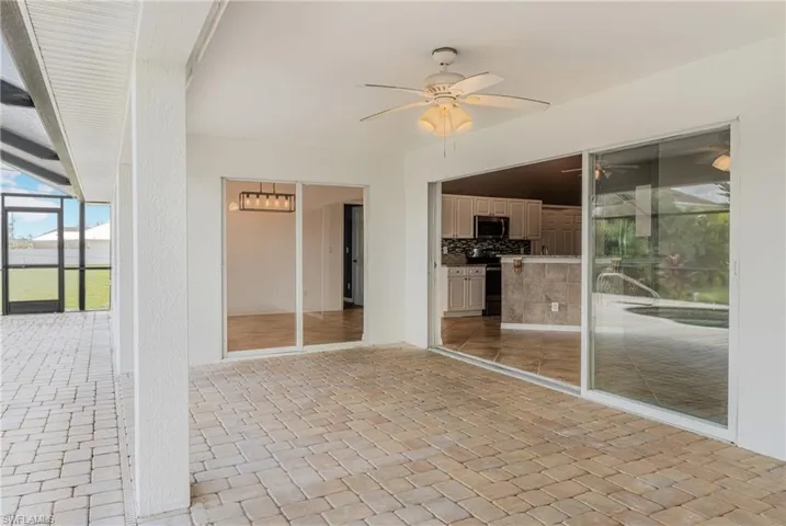 View of patio featuring glass enclosure and ceiling fan