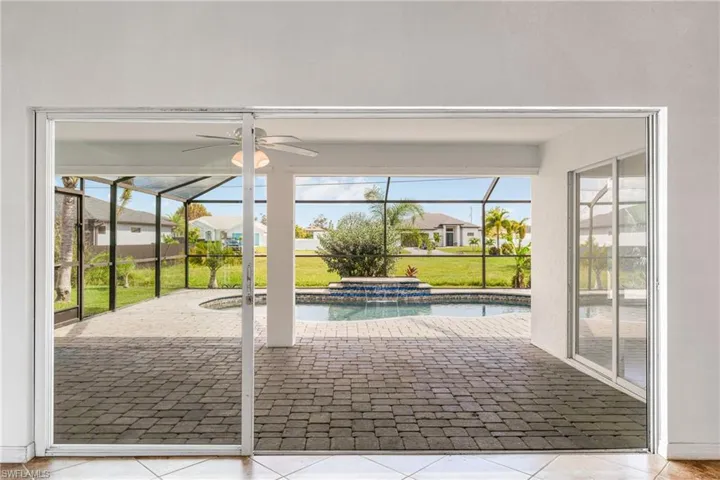 Doorway to outside with ceiling fan, a healthy amount of sunlight, and light tile patterned floors