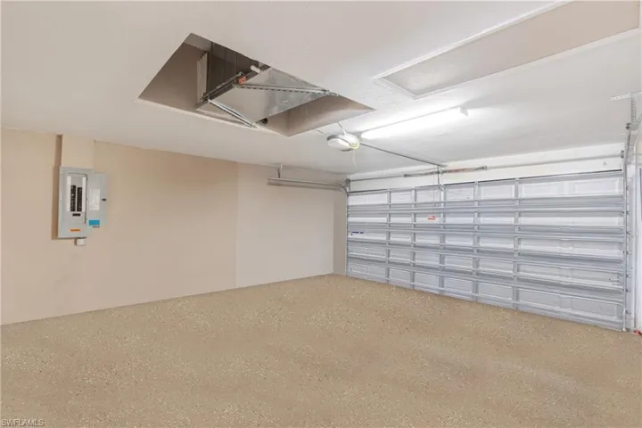 Garage featuring electric panel and a garage door opener