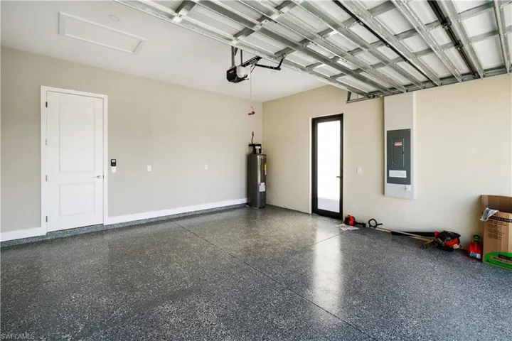 Garage featuring water heater and electric panel