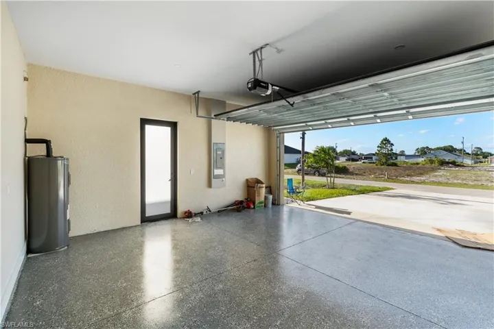 Garage with water heater, a residential view, and electric panel