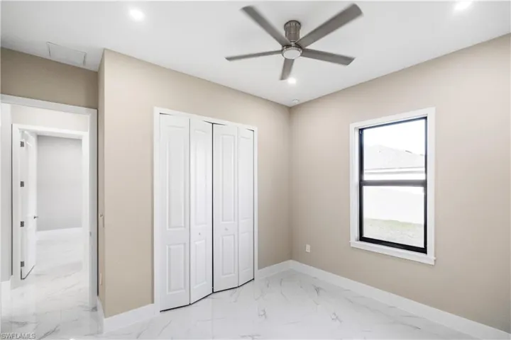 Unfurnished bedroom with light marble finish flooring, ceiling fan, a closet, and recessed lighting