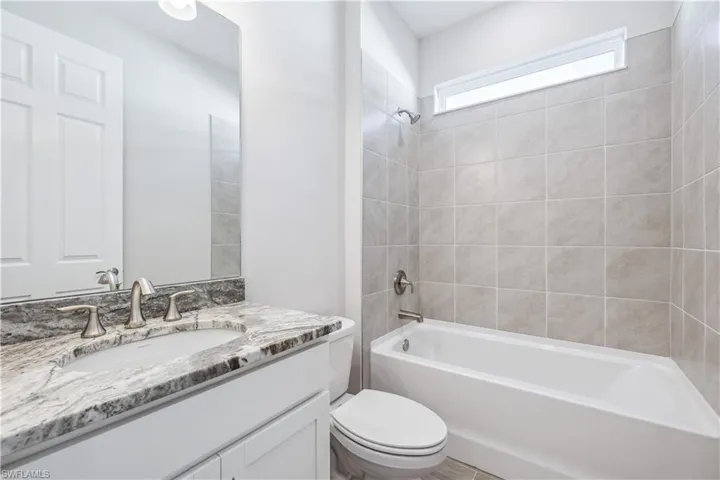 Full bathroom featuring toilet, vanity, and tiled shower / bath