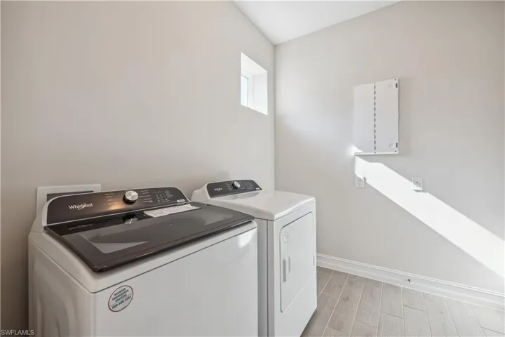 Laundry area featuring washing machine and dryer and light hardwood / wood-style floors