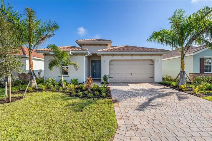 Mediterranean / spanish house featuring a garage and a front lawn