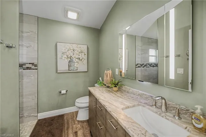 Bathroom vanity featuring a single undermount sink, dual chrome faucets, and a light-toned patterned countertop