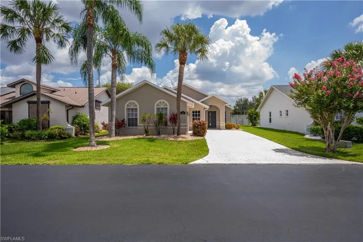 Stucco exterior residence featuring arched windows and a prominent front entrance