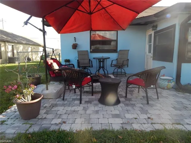 Fenced backyard with a patio, a water view, and an outdoor living space with a fire pit